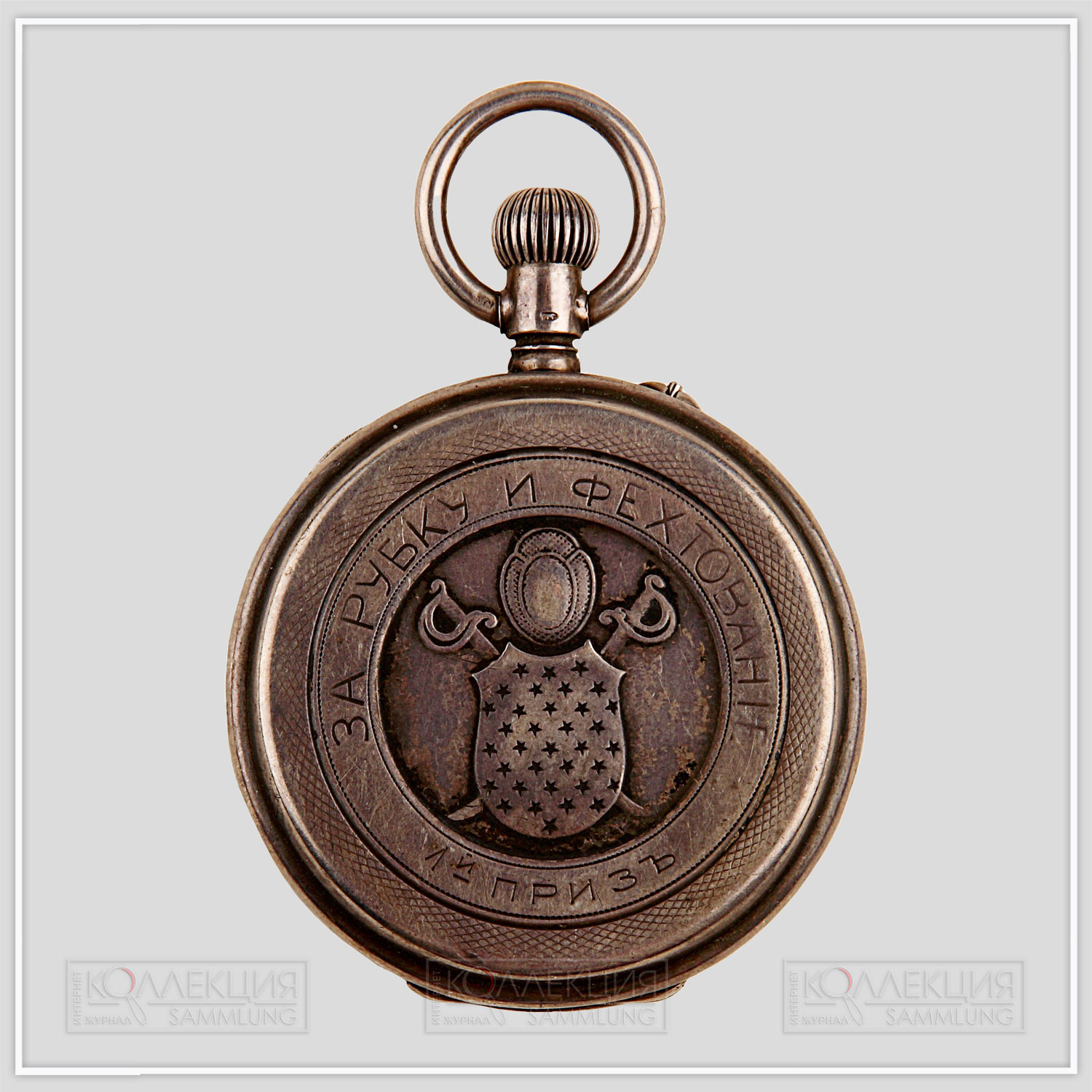 Серебряные закрытого типа (трёхкрышечные), Павел Буре. Тип корпуса «барабан» (drum), с гильоше, размер 50 мм, ремонтуар. На верхней крышке штампованное выпуклое изображение фехтовальной маски, перекрещенные сабли с защитным щитом и гравированная надпись: «1-й приз за рубку и фехтование». На внутренней стороне верхней крышки гравированная надпись: «уряднику 2-й сотни 12 Донского казачьего полка Алексею Дьяконову»