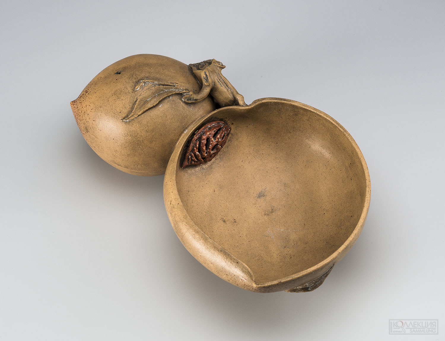 Сосуд для мытья кистей в виде половины плода персика на ветке с целым плодом. Китай, Исин (провинция Цзянсу). XVIII в. Династия Цин (1644–1911), правление Цяньлун (1736–1795). Керамическая масса; лепка, рельеф. Диаметр: 17,2 см. Государственный Эрмитаж, Санкт-Петербург